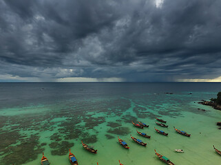 Image showing Long tail boats at beach and storm clouds