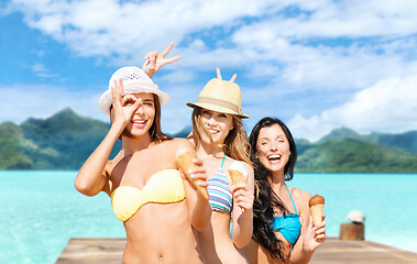 Image showing young women in bikini with ice cream on beach