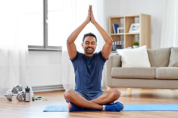 Image showing indian man meditating in lotus pose at home