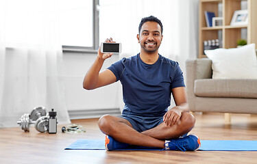 Image showing indian man with smartphone on exercise mat at home