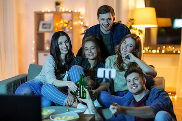 Image showing friends taking picture by selfie stick at home