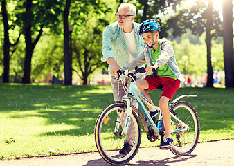 Image showing grandfather and boy with bicycle at summer park