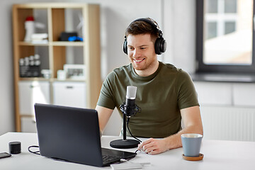 Image showing man with laptop and microphone at home office