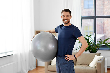 Image showing man exercising with fitness ball at home