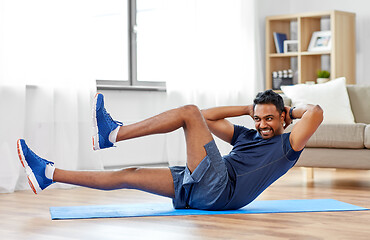 Image showing indian man making abdominal exercises at home