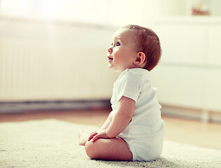 Image showing happy baby boy or girl sitting on floor at home