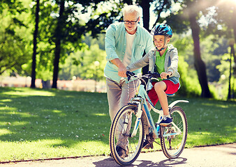 Image showing grandfather and boy with bicycle at summer park