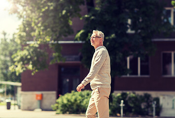 Image showing senior man walking along summer city street