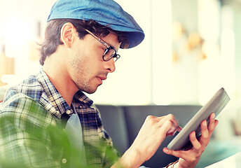 Image showing man with tablet pc sitting at cafe table