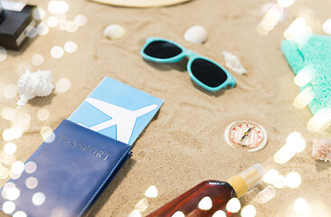 Image showing travel tickets, camera and hat on beach sand