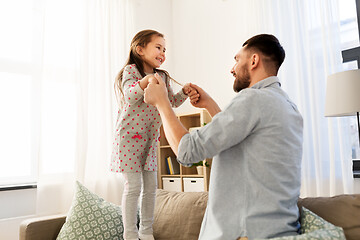 Image showing father and daughter jumping and having fun at home