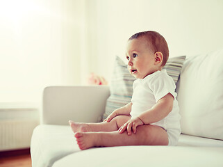 Image showing happy baby boy or girl sitting on sofa at home