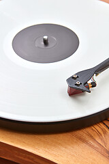 Image showing Vintage record player with vinil disc on a wooden table.