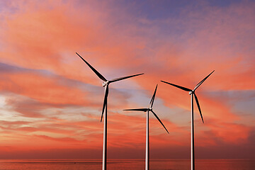 Image showing Wind turbines as alternative renewable energy on a background sunset sky.