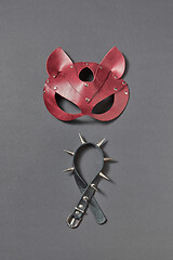 Image showing Leather collar with sharp spines and cat BDSM mask on a black background.