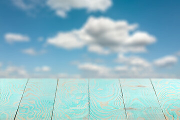 Image showing Empty wooden backdrop of blue color on a background of blurred sky.