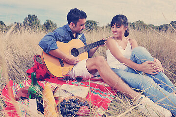 Image showing happy couple enjoying countryside picnic in long grass