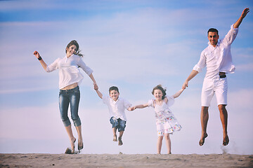 Image showing family on beach showing home sign