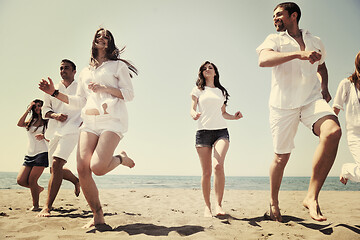 Image showing happy people group have fun and running on beach