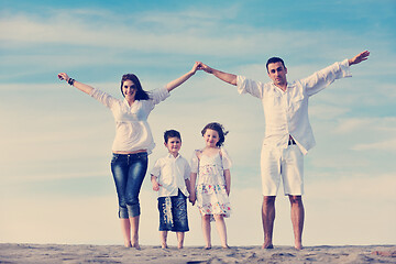 Image showing family on beach showing home sign