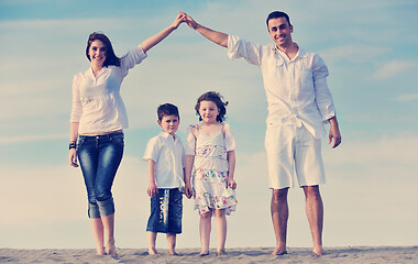 Image showing family on beach showing home sign