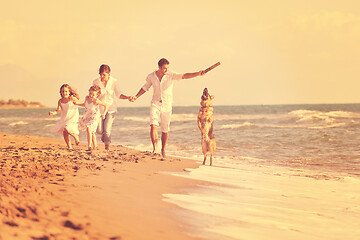 Image showing happy family playing with dog on beach