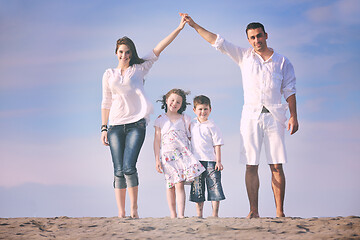 Image showing family on beach showing home sign