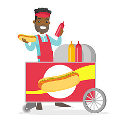 Image showing African-american street seller making a hot dog.