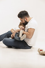 Image showing happy family with kid sitting together and smiling at camera isolated on white