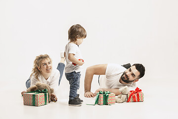 Image showing happy family with kid together and smiling at camera isolated on white