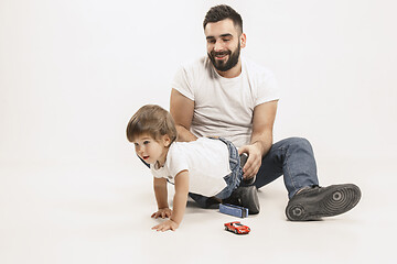 Image showing happy family with kid sitting together and smiling at camera isolated on white