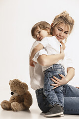 Image showing happy family with kid sitting together and smiling at camera isolated on white