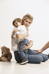 Image showing happy family with kid sitting together and smiling at camera isolated on white