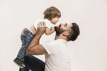 Image showing happy family with kid sitting together and smiling at camera isolated on white