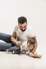 Image showing happy family with kid sitting together and smiling at camera isolated on white