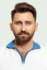 Image showing The serious man standing and looking at camera against white background.