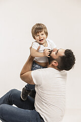 Image showing happy family with kid sitting together and smiling at camera isolated on white