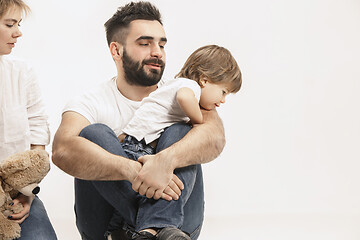 Image showing happy family with kid sitting together and smiling at camera isolated on white