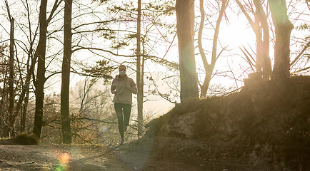 Image showing Corona virus, or Covid-19, is spreading all over the world. Portrait of caucasian sporty woman wearing a medical protection face mask while running in nature.