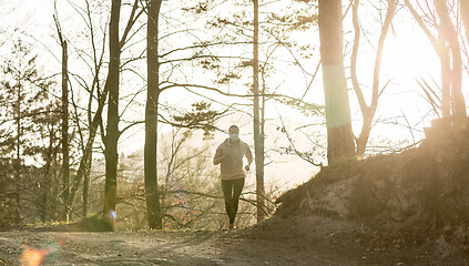 Image showing Corona virus, or Covid-19, is spreading all over the world. Portrait of caucasian sporty woman wearing a medical protection face mask while running in nature.