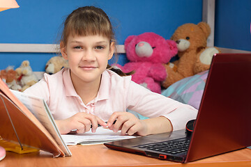 Image showing remote learning at home with a laptop and a textbook