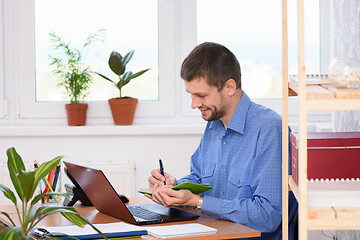 Image showing Office employee takes notes in a diary