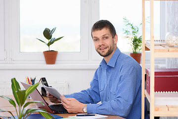 Image showing Business man distracted from papers and looked into the frame