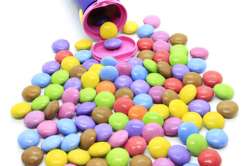 Image showing Multicolored glazed chocolate candies out of the container 