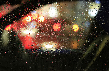 Image showing Lights of night city through the glass of the car with raindrops