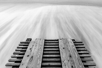 Image showing A breaking pier and surf washed out with a long exposure, black and white photo