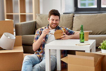 Image showing smiling man eating takeaway food at new home