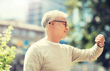 Image showing senior man checking time on his wristwatch