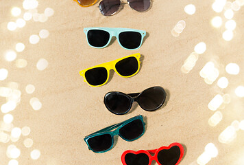 Image showing different sunglasses on beach sand