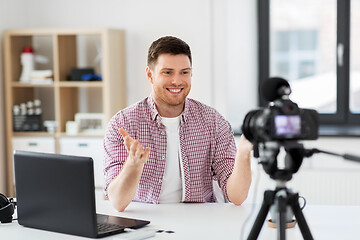 Image showing male blogger with camera videoblogging at home